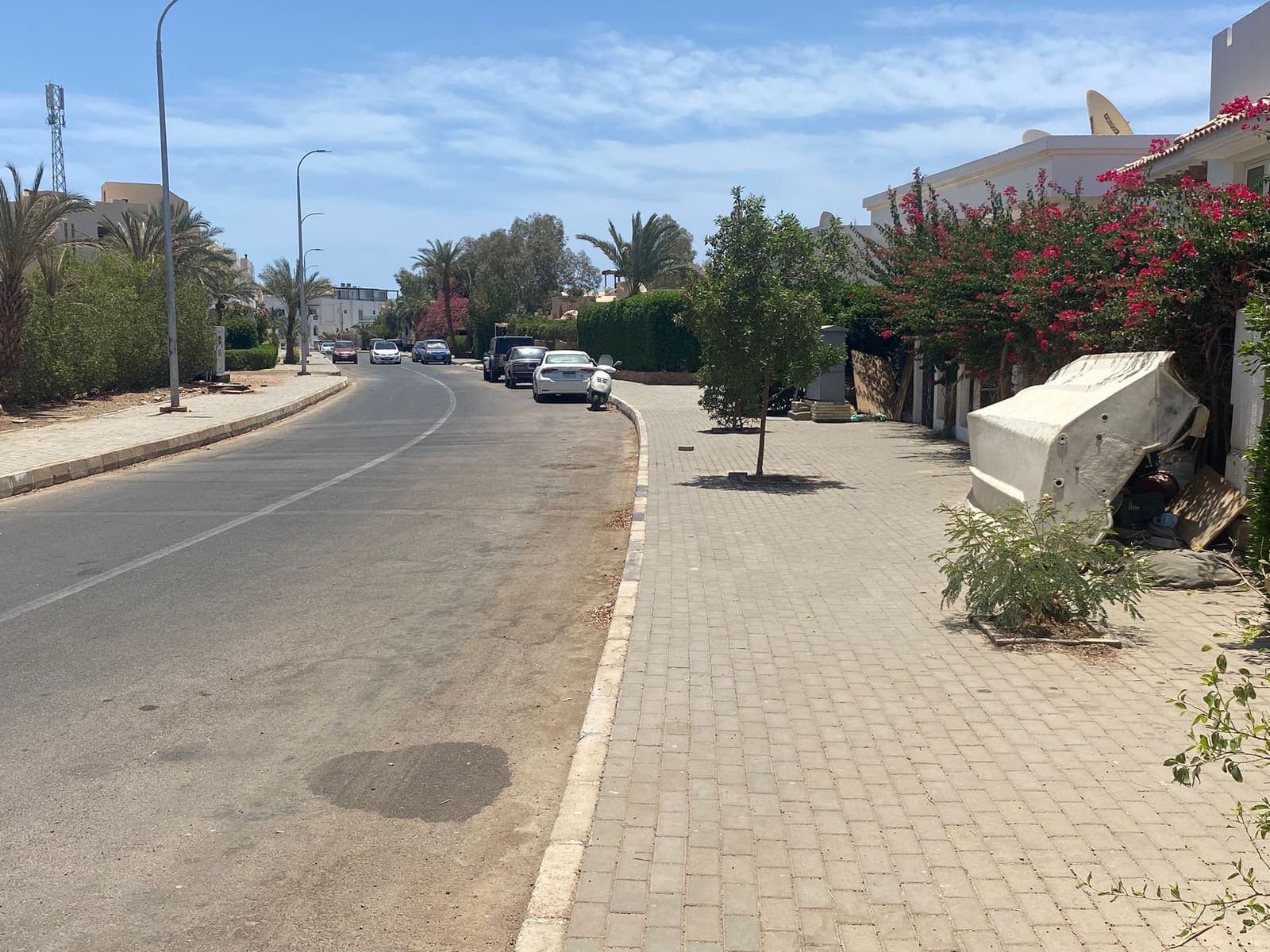 Strada residenziale di Hadaba con palme e ville bianche