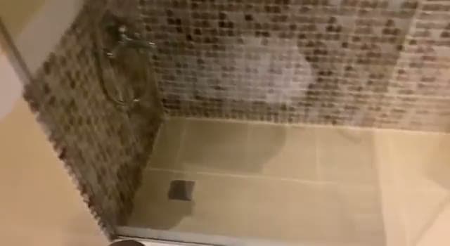 Il bagno della camera all'Amwaj Hotel: doccia a filo pavimento con le pareti rivestite in mosaico beige e marrone