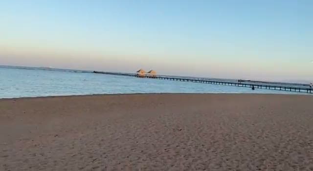 La spiaggia dell'Amwaj Hotel con il lungo pontile che si allunga sull'acqua bassa fino ai gazebo in paglia