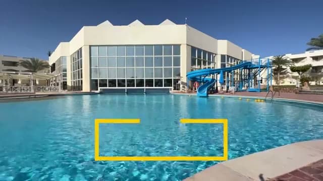 La piscina centrale dell'Aurora Oriental con lo scivolo per bambini e l'edificio principale sullo sfondo
