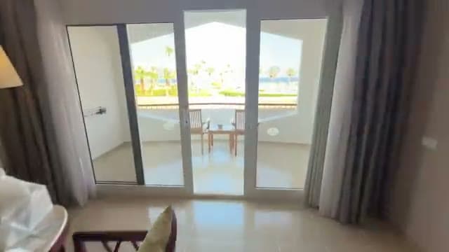 Il balcone della camera del Baron Resort con vista su piscina, spiaggia e l'isola di Tiran sullo sfondo