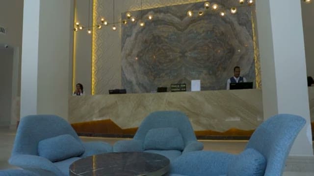 La reception del Bellagio a Hurghada con la parete in marmo venato e le poltroncine azzurre della lobby