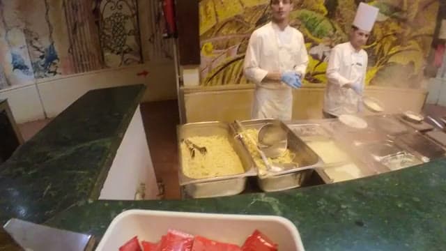 Due cuochi alla postazione del buffet del Caribbean World Hurghada dove la pasta viene preparata al momento, dietro il bancone in marmo verde con le vaschette degli ingredienti