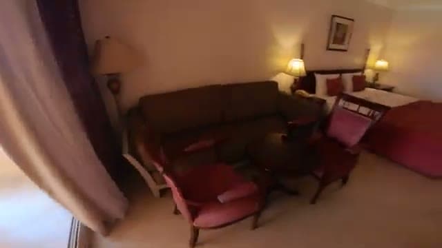 Il salottino della camera del Caribbean World Hurghada con il divano, le poltrone rosse, il tavolino tondo in legno scuro e le lampade dallo stile datato