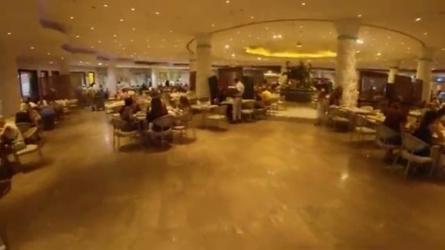 La sala del ristorante principale del Caribbean World Hurghada, ampia e scandita da colonne, già piena di ospiti ai tavoli la sera