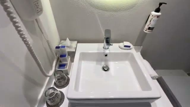 Il lavabo del bagno della camera del Casa Blu, con il phon, i bicchieri e il dispenser di sapone