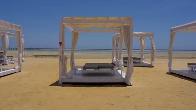I gazebo bianchi sulla sabbia della spiaggia del Casa Blu, affacciati sull'acqua bassa e trasparente