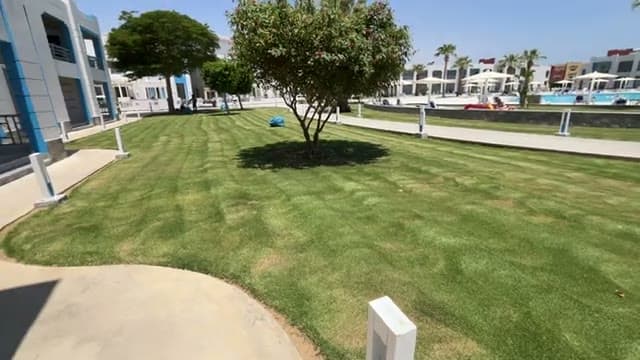 I giardini curatissimi del Casa Blu tra gli edifici bianchi e azzurri, con le piscine sullo sfondo