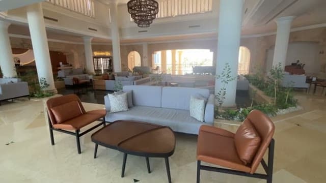 La hall del Casa Blu a Marsa Alam, con colonne, divani chiari e poltrone in pelle attorno alle aiuole interne