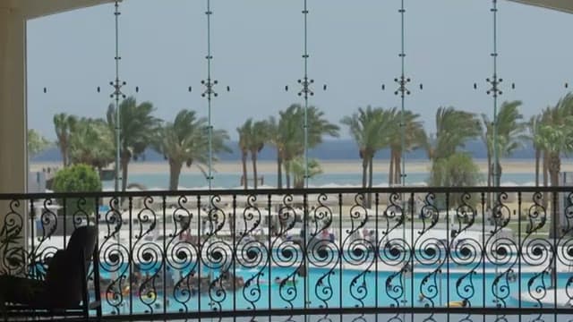 La vista sul mare e sulla piscina dalla terrazza sopra la scalinata del Casa Blu, con le palme mosse dal vento