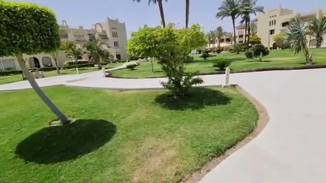 Il giardino centrale del Coral Sea Waterworld: prato verde curato, vialetti e palme in mezzo al deserto di Nabq