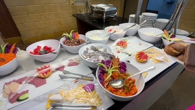 Il buffet salato del Dive Inn con insalate, verdure e affettati nelle ciotole bianche