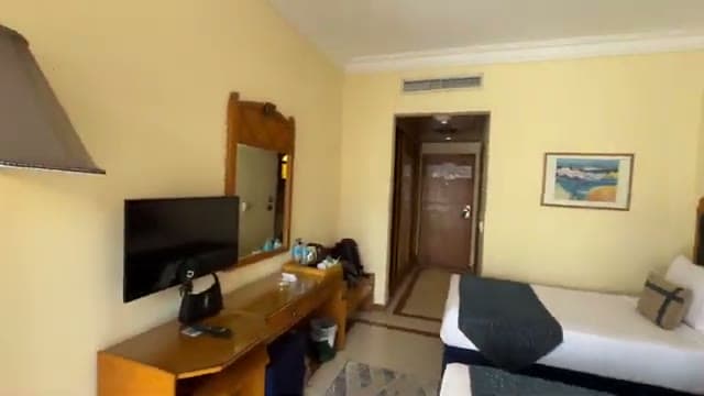 La camera del Dive Inn con i letti, la televisione, lo specchio e la scrivania in legno