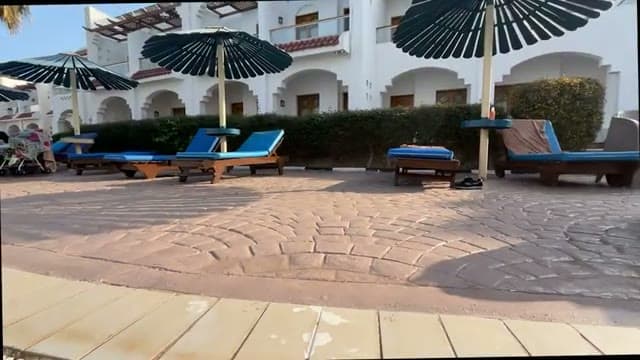 I lettini blu con gli ombrelloni davanti alle camere del Dive Inn