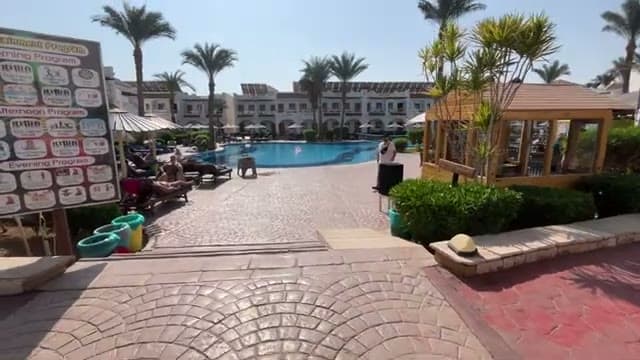 La piscina del Dive Inn Resort circondata dalle casette bianche, con gli ombrelloni e la zona animazione