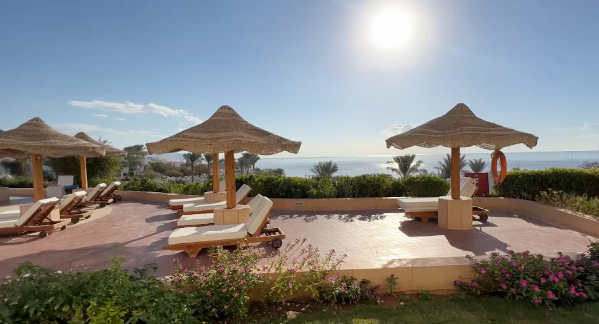 Le sdraio in legno di una terrazza del Domina Coral Bay al mattino, con vista sul mare