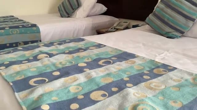 I due letti della camera del Dreams Beach con i copriletto a fantasia e il comodino con il telefono