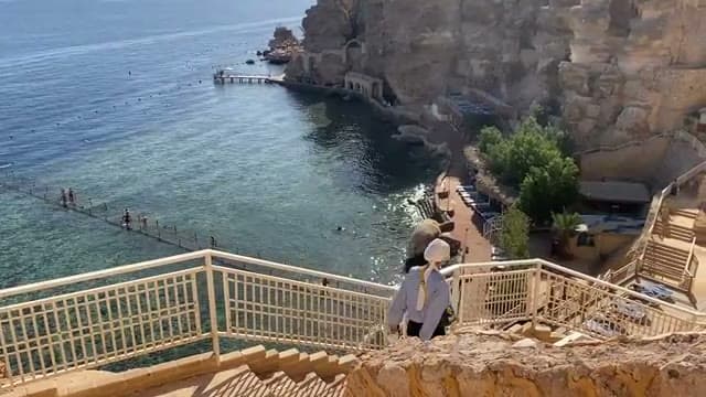 La lunga scalinata che dal Dreams Vacation scende fino alla spiaggia, con la baia e il pontile visti dall'alto