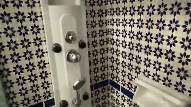 Il box doccia della camera del Faraana Heights rivestito di piastrelle decorate blu e bianche