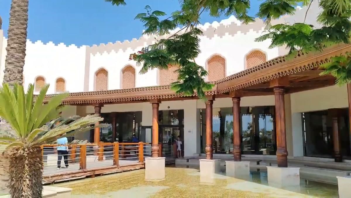 L'ingresso porticato del Ghazala Gardens a Naama Bay, con le colonne in legno e la vasca d'acqua davanti alla hall