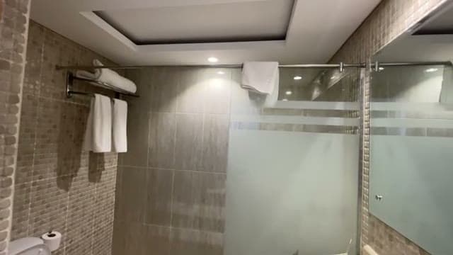 Il bagno del Grand Oasis Resort con piastrelle chiare e la doccia che occupa tutta la lunghezza dello spazio