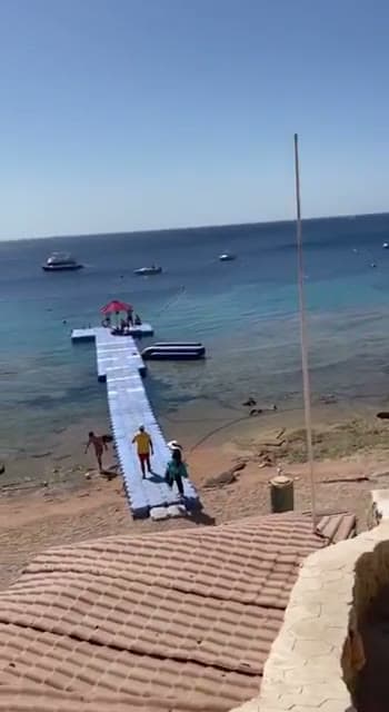 Il pontile galleggiante dell'Hilton Sharks Bay che attraversa il reef, con i bagnanti che scendono verso la piattaforma delle attività