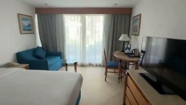 La camera 307 del Jaz Fayrouz Sharm al primo sguardo: divano blu, tavolino e grande finestra sul giardino