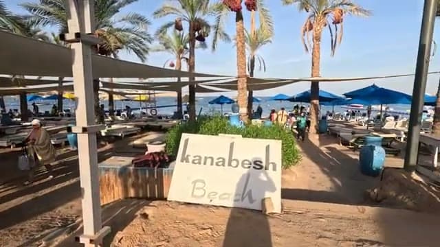 Il cartello "Kanabesh Beach" all'ingresso della spiaggia dell'hotel, fra le palme e le vele ombreggianti