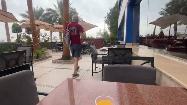 La terrazza esterna con i tavoli dove si mangia, sotto gli ombrelloni e le palme