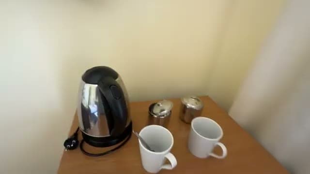 L'angolo bollitore della camera: bollitore, due tazze, zucchero e caffè