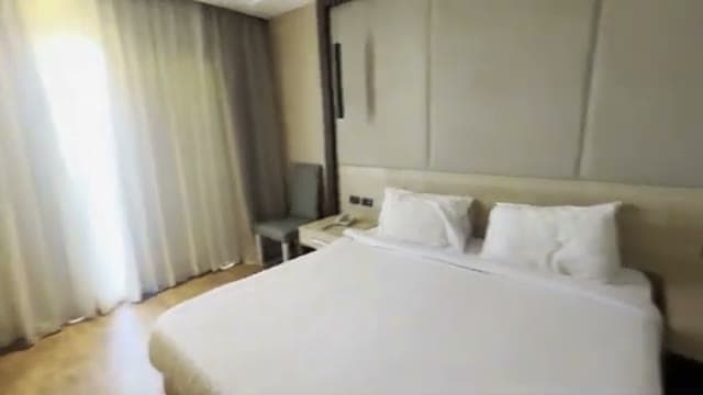 Il letto matrimoniale della camera del Panorama Naama Heights con la testiera imbottita e il pavimento in legno
