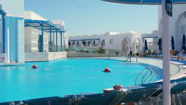 L'ingresso del PickAlbatros Palace con la piscina dalle acque limpidissime circondata da marmi bianchi e lettini blu
