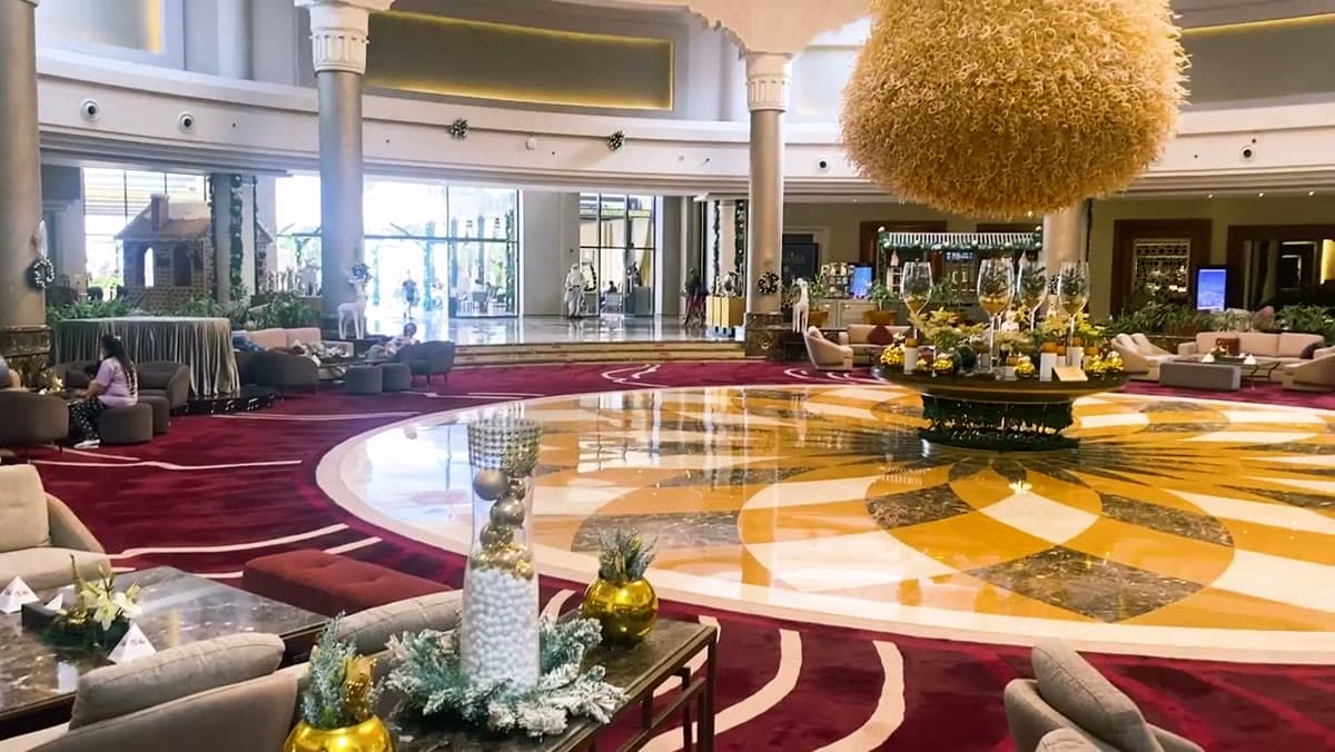 La lobby circolare del Rixos Premium Seagate con il colonnato, i marmi lucidi e il grande lampadario dorato sospeso