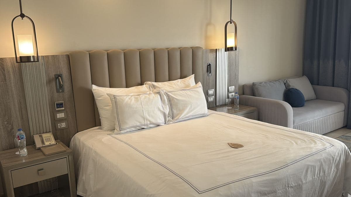 La camera Superior del Rixos Blue Planet con il letto matrimoniale, la testiera imbottita e il divano