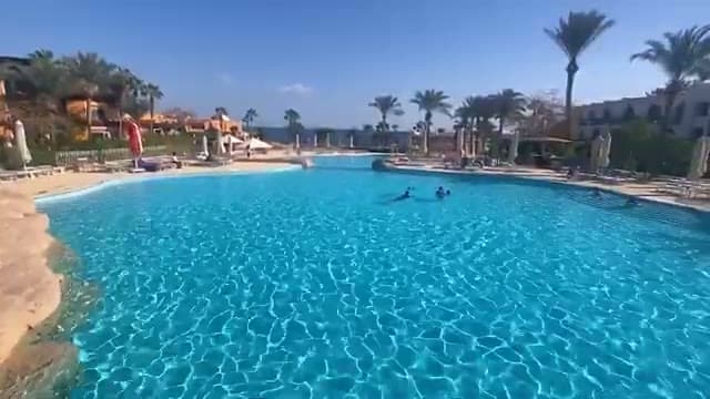 La grande piscina centrale del Savoy circondata dalle palme, con il mare sullo sfondo