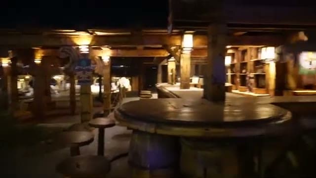 Il bar esterno dello Sharm Dreams illuminato la sera, con i tavoli in legno e gli sgabelli
