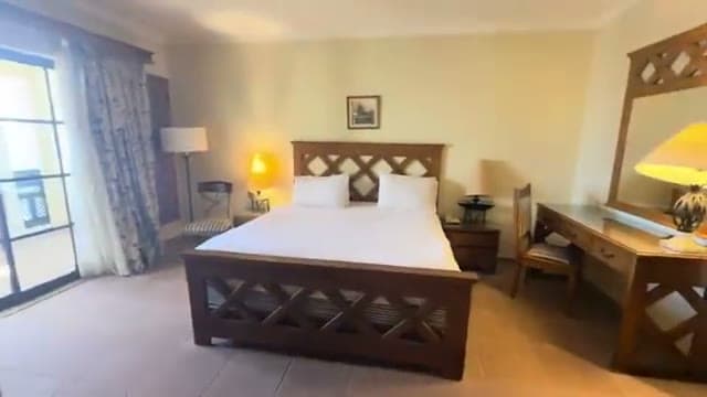 La camera Executive Suite di Sharm Plaza, con l'arredamento in stile datato e il letto matrimoniale