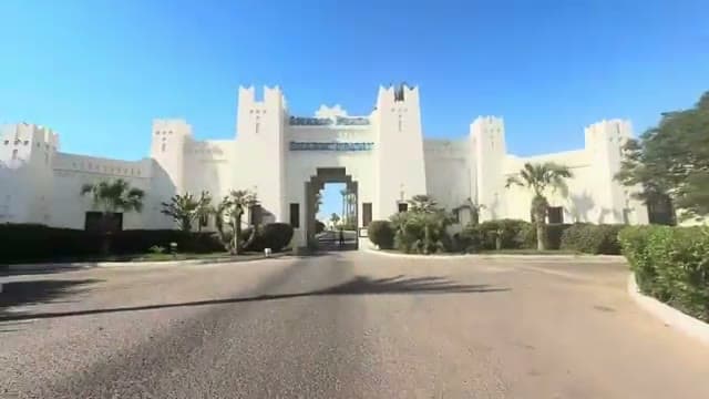 La facciata fortificata di Sharm Plaza vista dall'ingresso, con l'insegna sopra il grande arco d'accesso