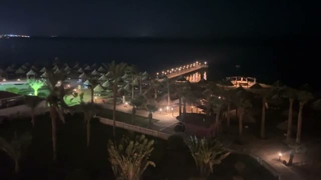 Il pontile dello Sheraton Sharm illuminato di notte, visto dall'alto sopra i giardini e la zona mare
