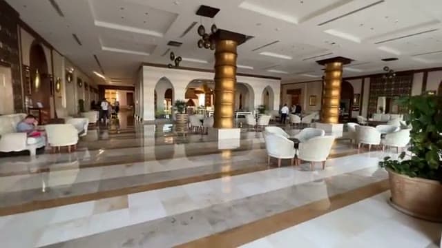 La lobby imperiale del Sunrise Arabian Beach Resort, con colonne dorate, sedute in velluto e pavimenti in marmo