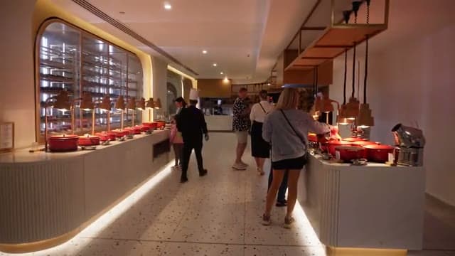 Il ristorante buffet principale del Sunrise White Hills la sera, con le pentole in ghisa rossa lungo il banco illuminato
