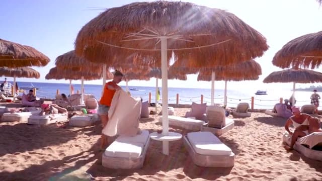 La spiaggia del Sunrise White Hills con gli ombrelloni di paglia e i lettini imbottiti sulla sabbia davanti al mare