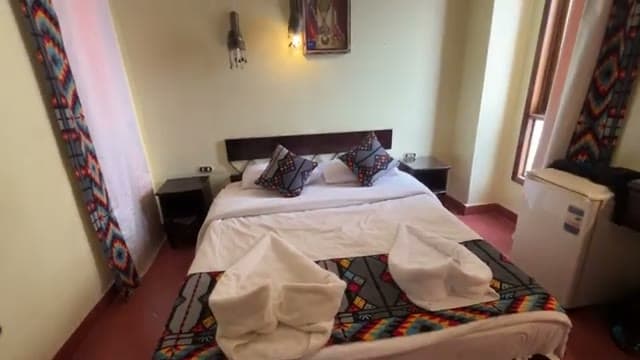 La camera doppia dell'Umbi Sharks Bay con il letto matrimoniale, gli asciugamani a forma di cuore e i tessuti etnici colorati