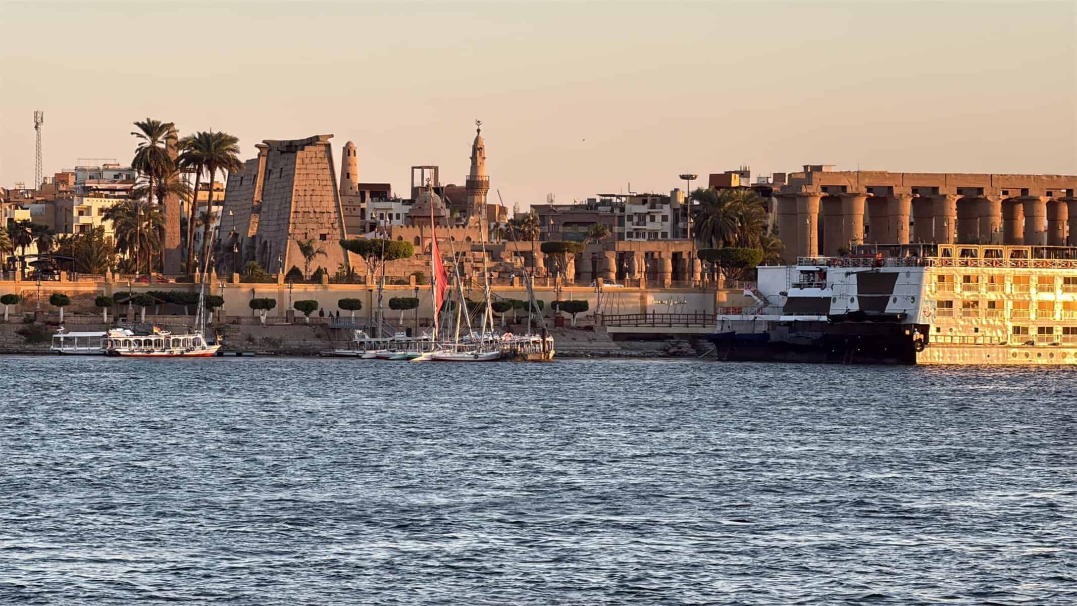 Il Nilo e visto sul tempio di Luxor dalla barca al tramonto