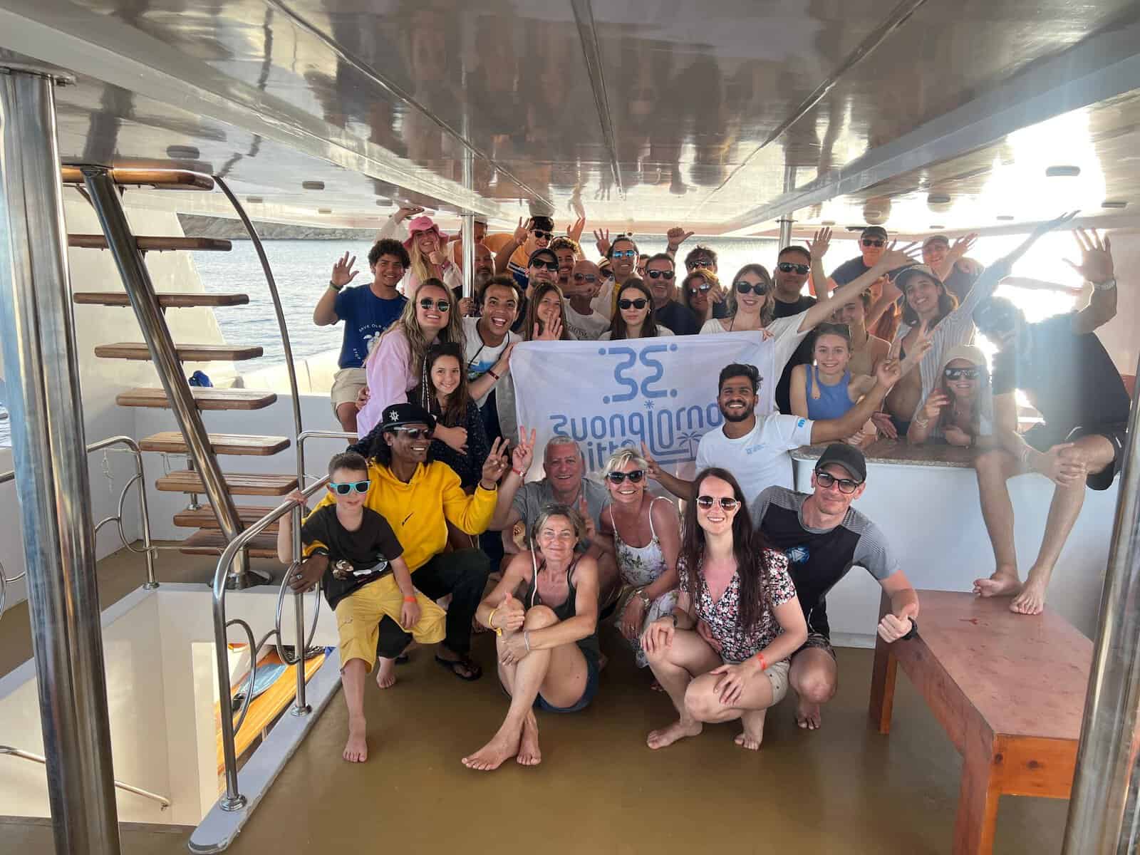 gruppo di persone sorridenti in barca con guida e bandiera di buongiorno egitto