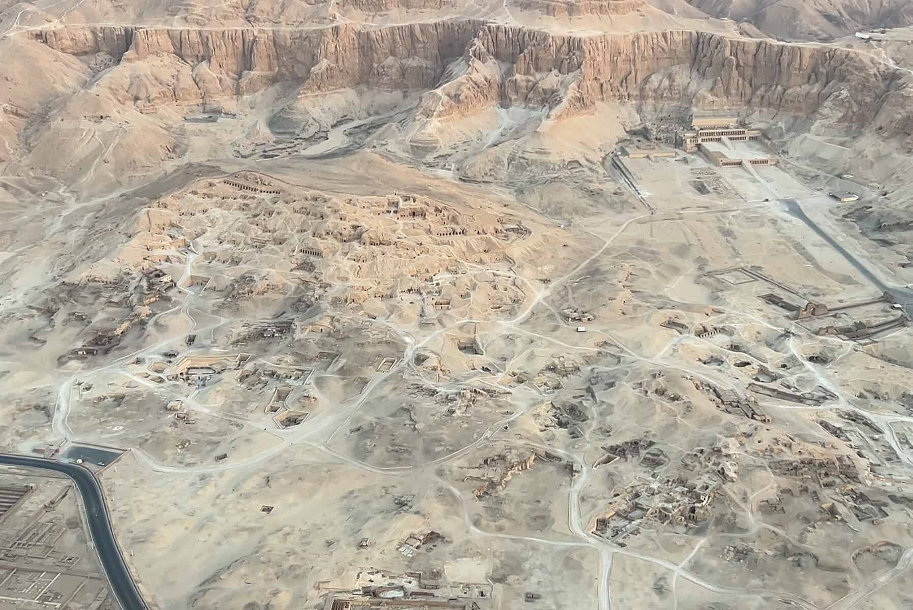 Vista aerea della Valle dei Re a Luxor con tombe scavate nella roccia, montagne desertiche e il Nilo sullo sfondo