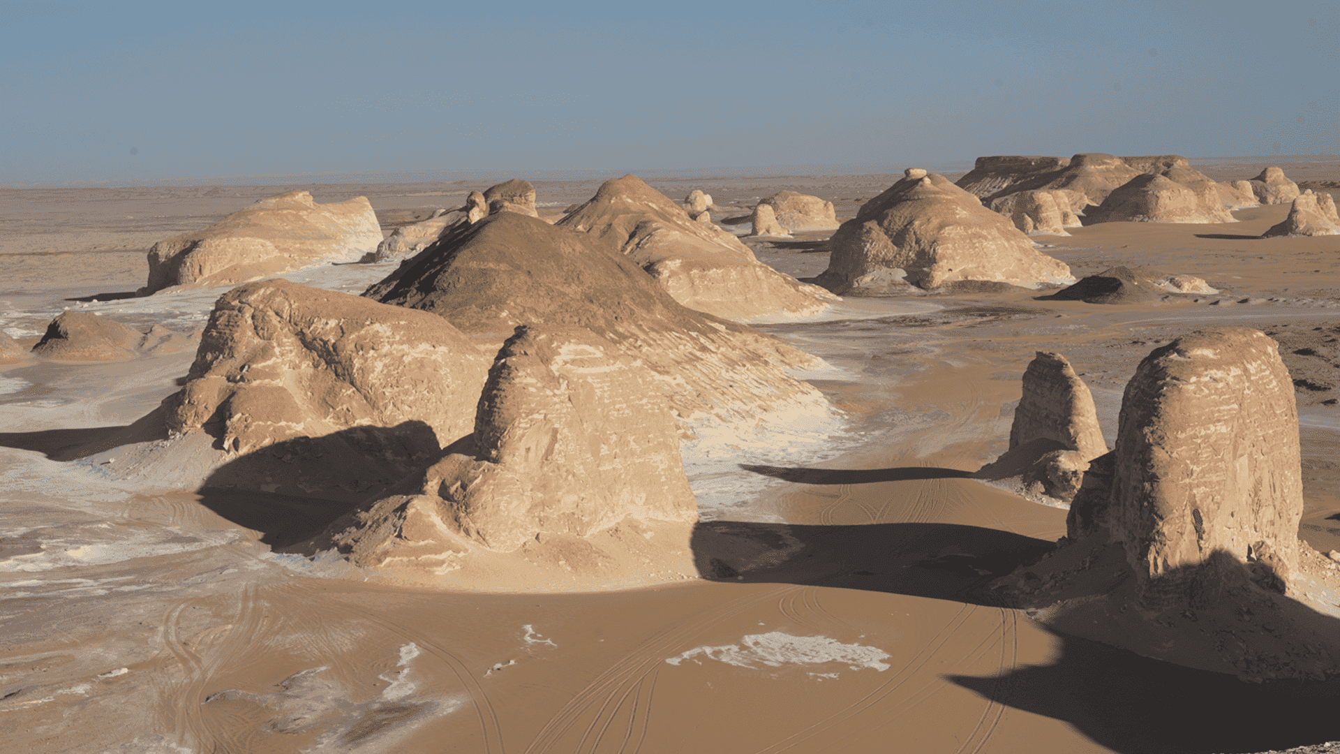 Formazioni rocciose calcaree isolate nel deserto bianco egiziano con sabbia e depositi salini tra loro