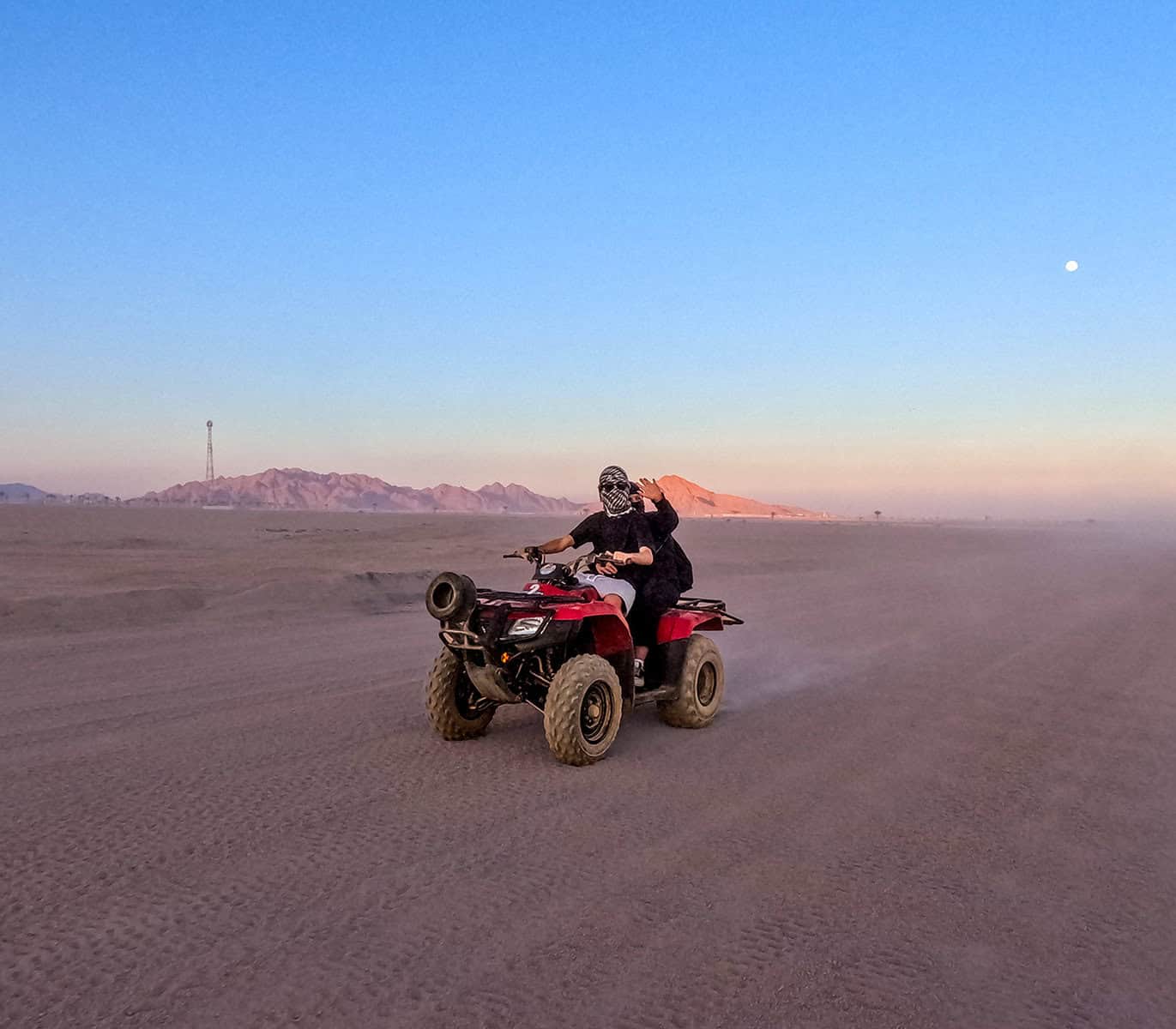 2 giovani in quad guidano nel deserto al tramonto durante la motorata