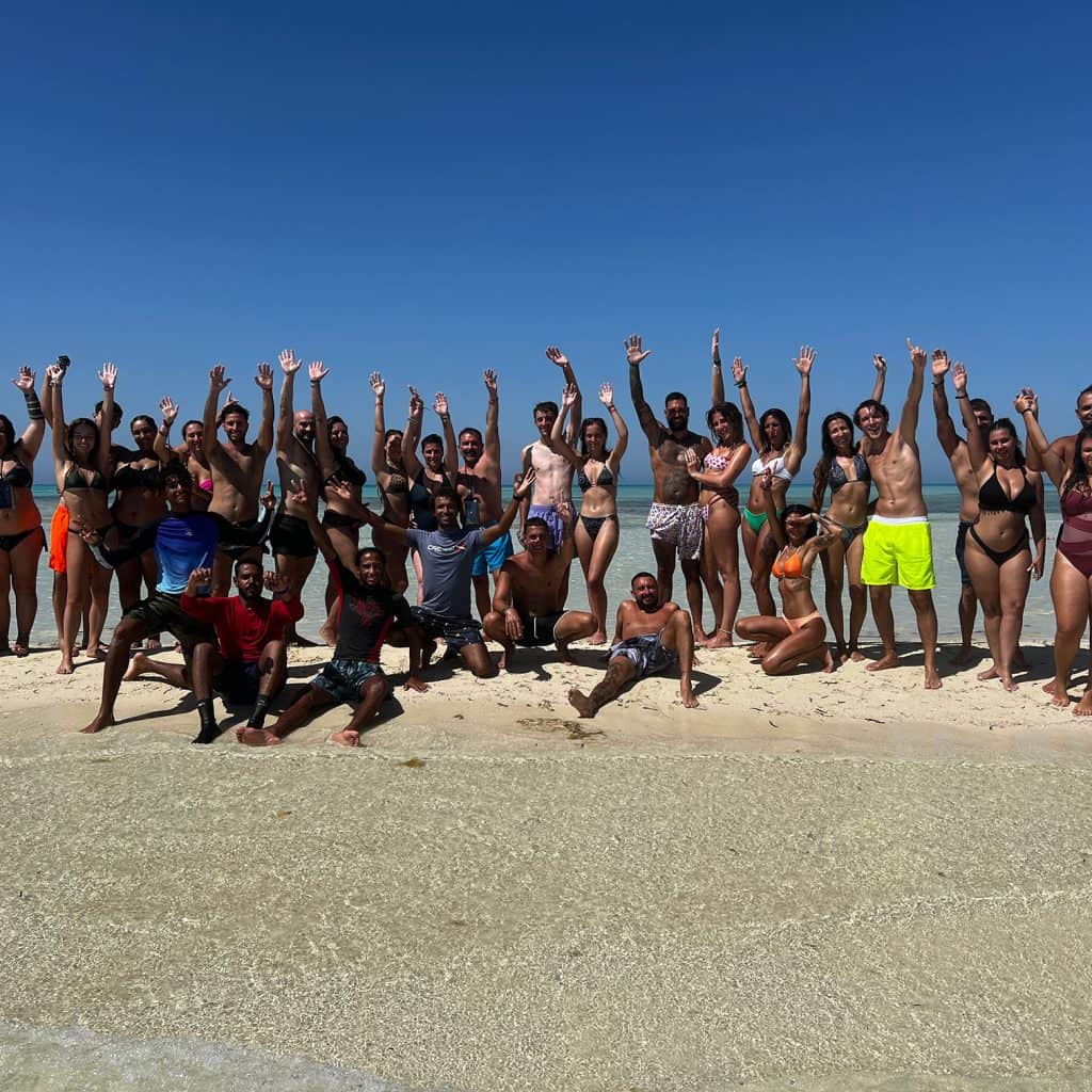 gruppo in costume alza le braccia all' isola che non c' e'